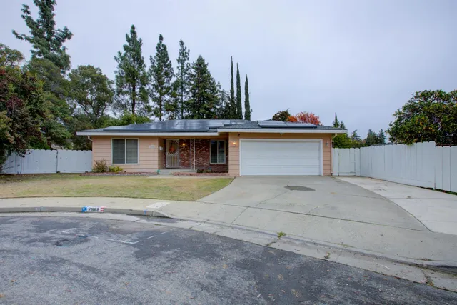 a view of house with outdoor space and trees in the background