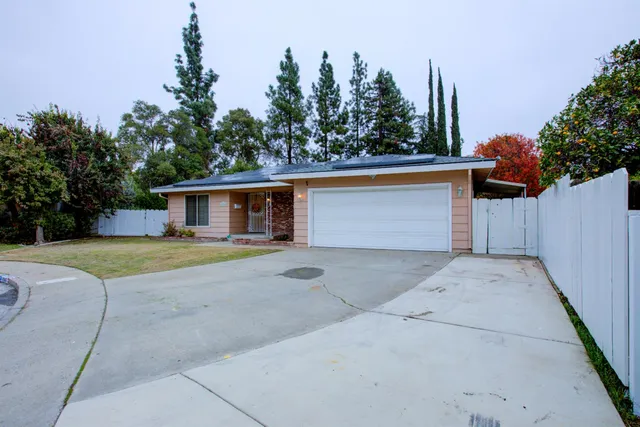 a front view of a house with a yard and trees