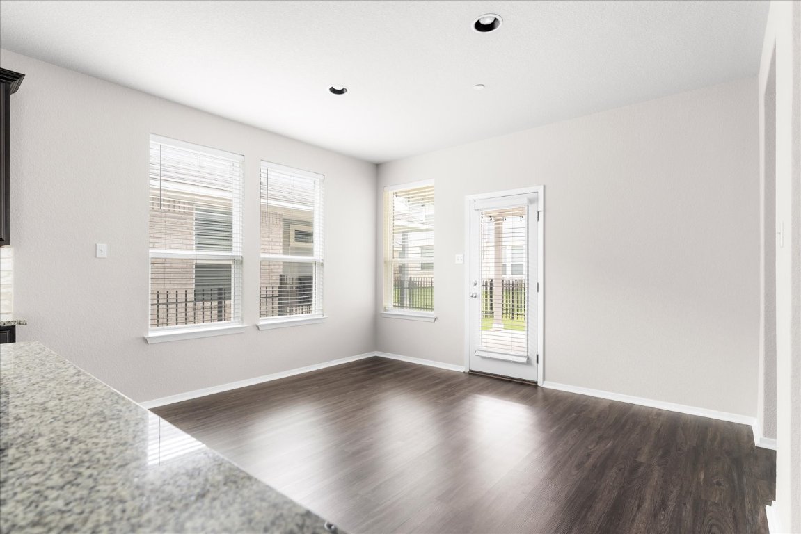 2800 Joe Dimaggio Boulevard, Unit 100 Round Rock, TX 78665 - Photo 10 of 33 an empty room with wooden floor and windows