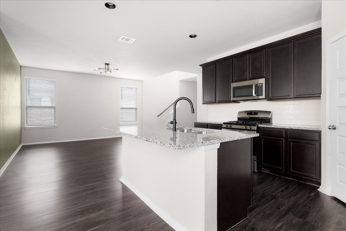 2800 Joe Dimaggio Boulevard, Unit 100 Round Rock, TX 78665 - Photo 11 of 33 a kitchen with granite countertop a stove top oven and sink
