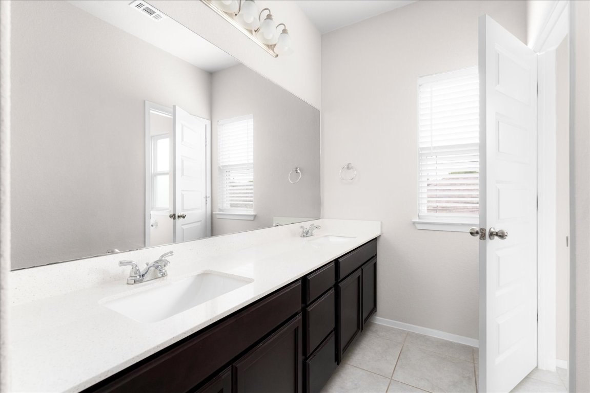 2800 Joe Dimaggio Boulevard, Unit 100 Round Rock, TX 78665 - Photo 25 of 33 a bathroom with a sink a mirror and a bathtub