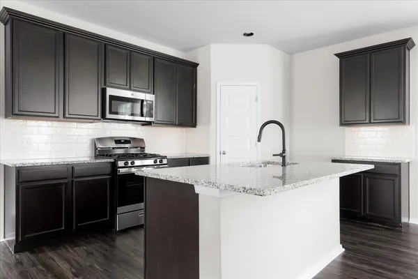 a kitchen with a sink a stove and cabinets