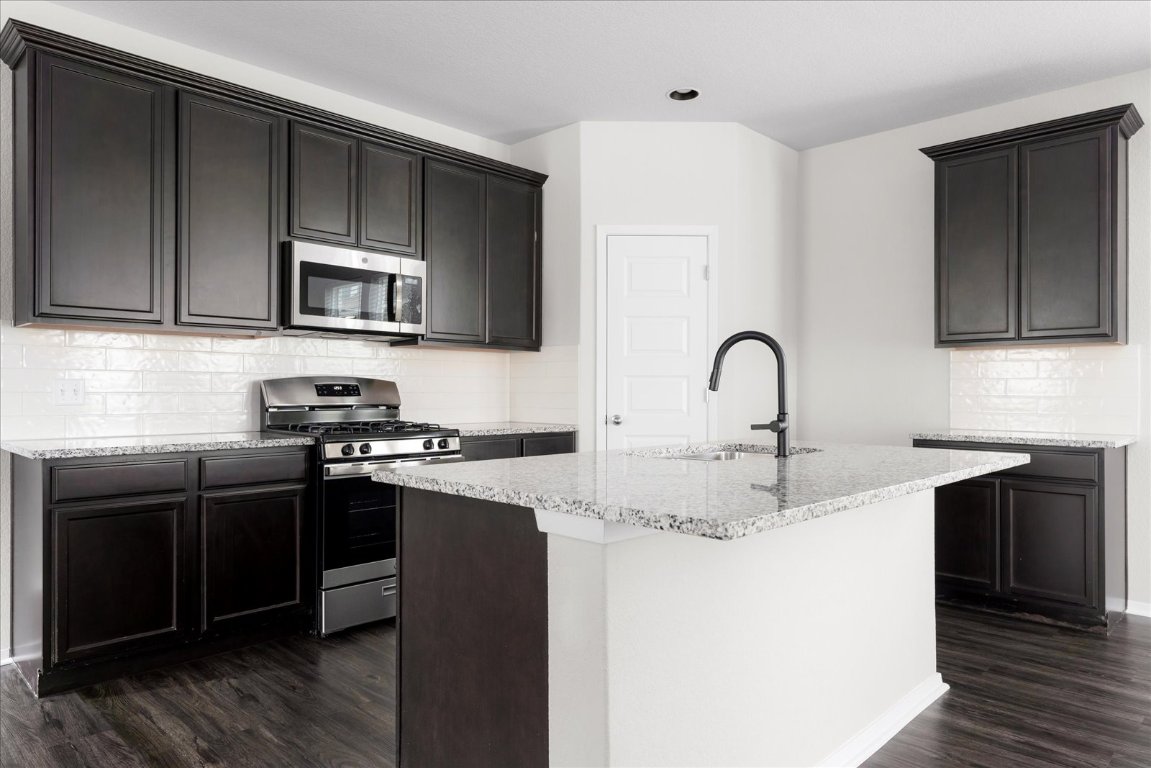 2800 Joe Dimaggio Boulevard, Unit 100 Round Rock, TX 78665 - Photo 7 of 33 a kitchen with stainless steel appliances granite countertop a stove a sink and a microwave