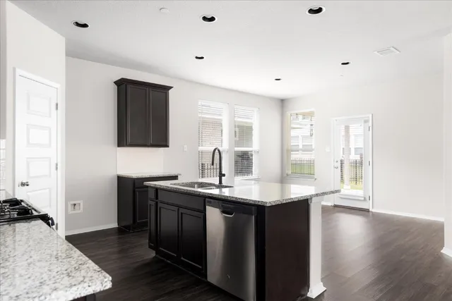 a kitchen with stainless steel appliances granite countertop a stove a sink and a microwave