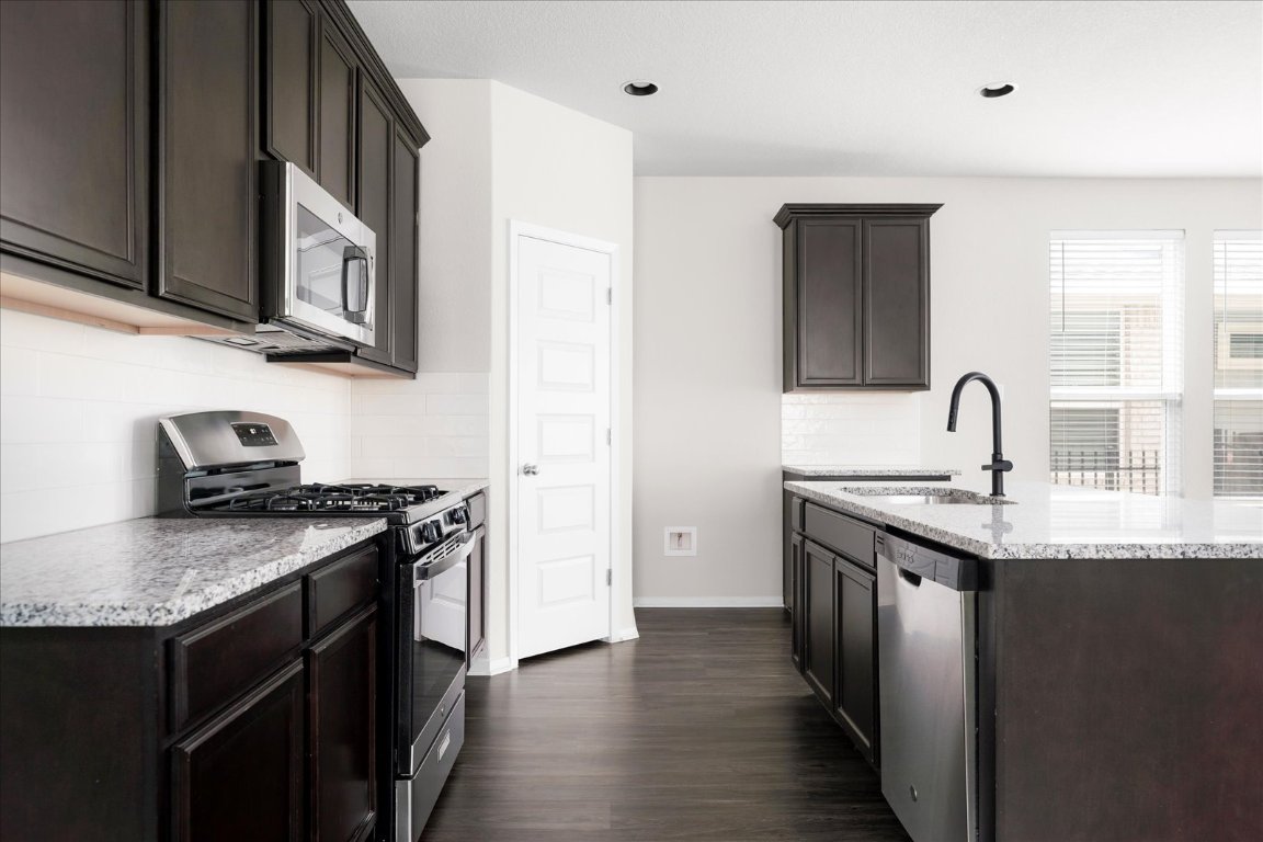 2800 Joe Dimaggio Boulevard, Unit 100 Round Rock, TX 78665 - Photo 9 of 33 a kitchen with stainless steel appliances granite countertop a sink stove and cabinets