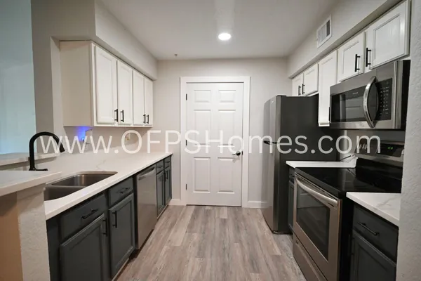 a kitchen with stainless steel appliances a sink stove and cabinets