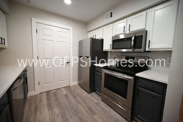 a kitchen with stainless steel appliances a stove microwave and sink