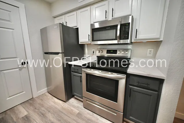 a kitchen with stainless steel appliances a stove a microwave and sink