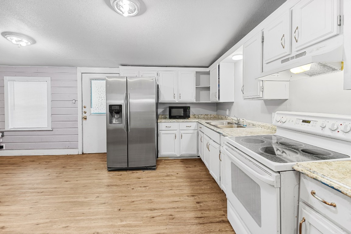 402 East 4th Street Taylor, TX 76574 - Photo 11 of 18 a kitchen with a refrigerator sink and cabinets