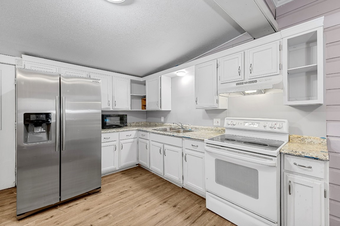 402 East 4th Street Taylor, TX 76574 - Photo 15 of 18 a kitchen with cabinets stainless steel appliances and a counter space