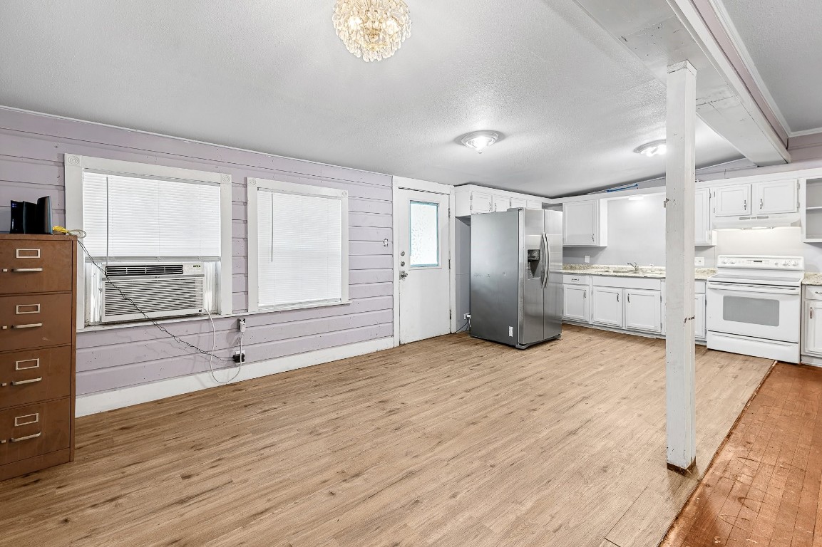 402 East 4th Street Taylor, TX 76574 - Photo 10 of 18 a view of a kitchen with refrigerator and wooden floor