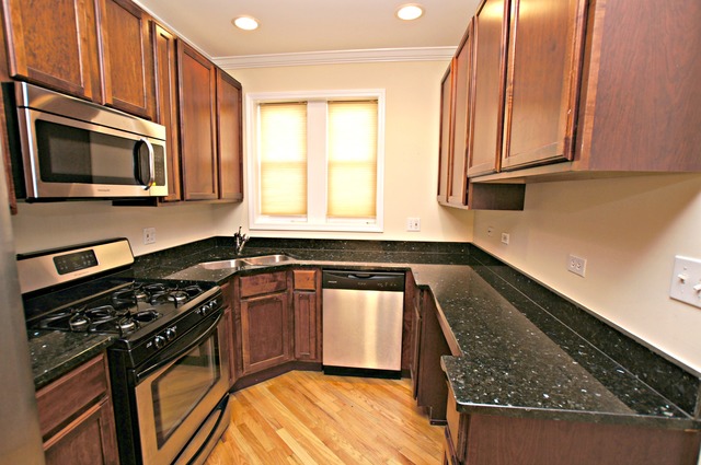 4110 North Keystone Avenue, Unit 3E Chicago, IL 60641 - Photo 11 of 21 a kitchen with stainless steel appliances granite countertop a stove a sink and a microwave