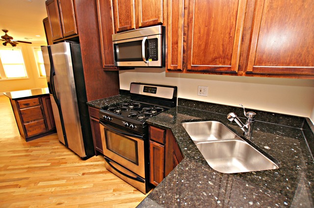 4110 North Keystone Avenue, Unit 3E Chicago, IL 60641 - Photo 12 of 21 a kitchen with granite countertop a sink a stove and cabinets
