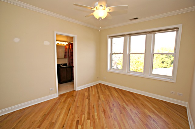 4110 North Keystone Avenue, Unit 3E Chicago, IL 60641 - Photo 14 of 21 an empty room with wooden floor chandelier fan and windows
