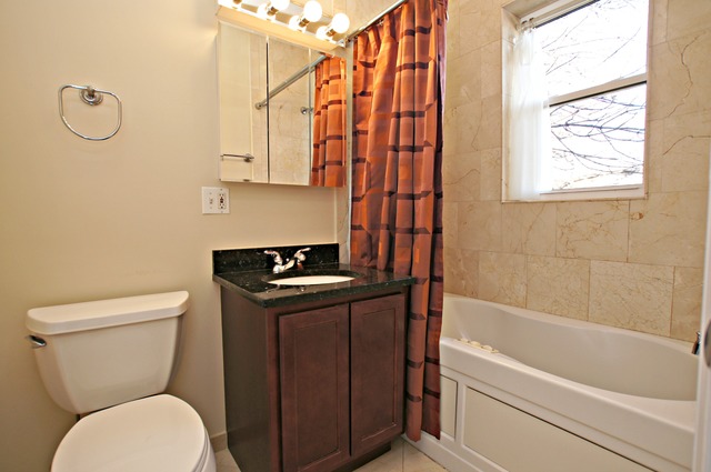 4110 North Keystone Avenue, Unit 3E Chicago, IL 60641 - Photo 16 of 21 a bathroom with a toilet sink and tub