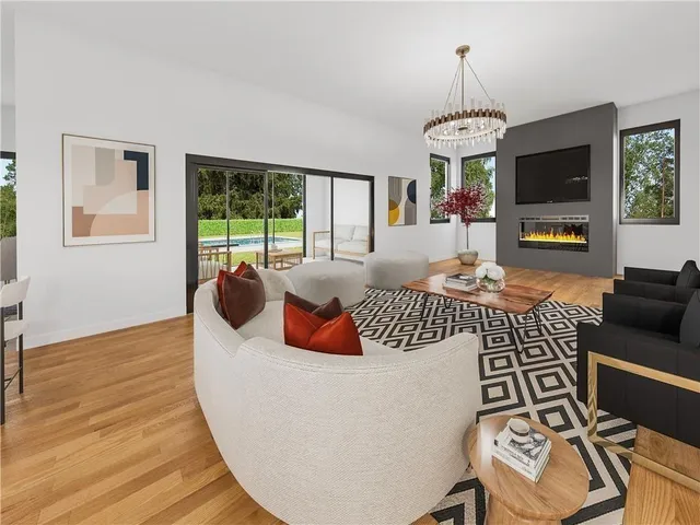 a living room with furniture a flat screen tv and a large window