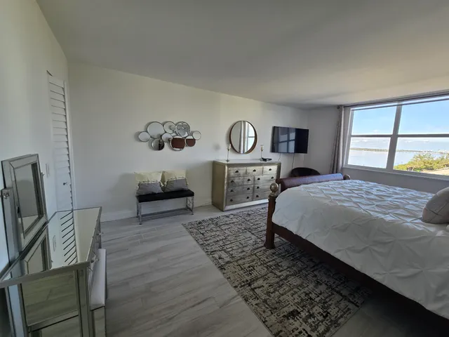 a bedroom with a large bed a rug and chair