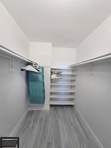a view of walk in closet with empty racks