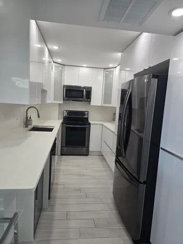 a kitchen with stainless steel appliances a refrigerator sink and microwave