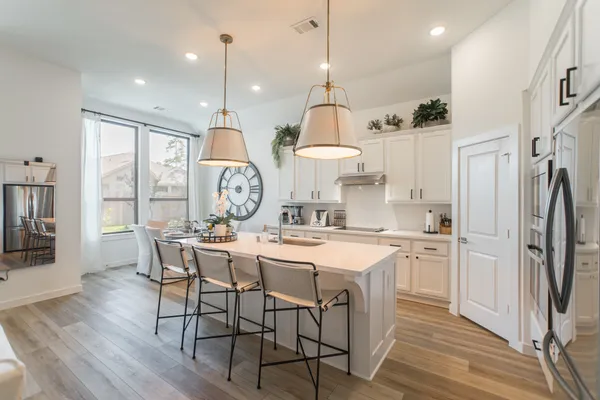 a kitchen with a refrigerator a stove a sink and a dining table with painted walls