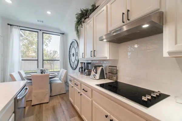 a kitchen with stainless steel appliances white cabinets and a refrigerator
