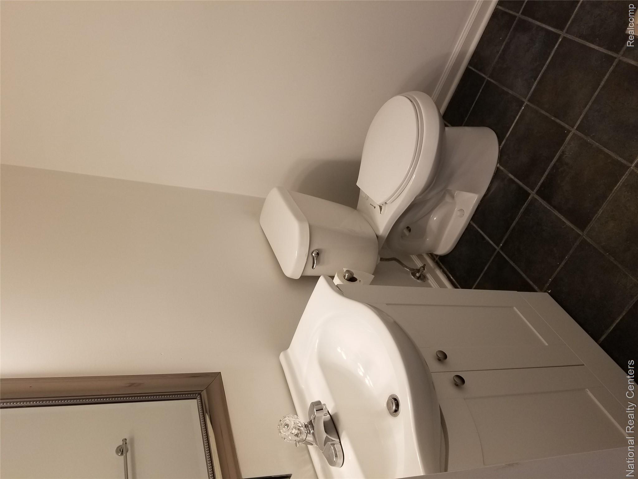 15175 Raphael Terrace Warren, MI 48088 - Photo 8 of 20 Bathroom featuring a white vanity with integrated sink, chrome faucet, and white two-piece toilet