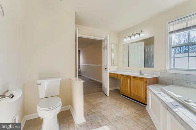 a bathroom with a granite countertop toilet sink and mirror