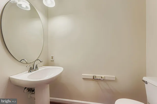 a bathroom with a sink mirror and toilet