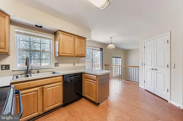 a kitchen with stainless steel appliances granite countertop a sink stove and wooden cabinets
