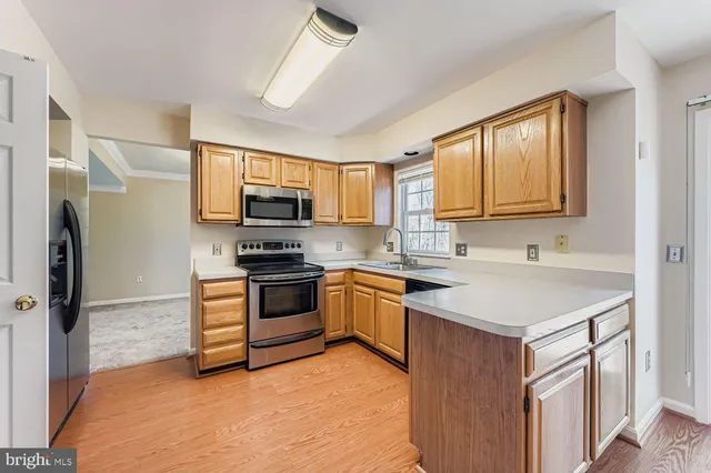 a kitchen with stainless steel appliances granite countertop a sink stove microwave and refrigerator