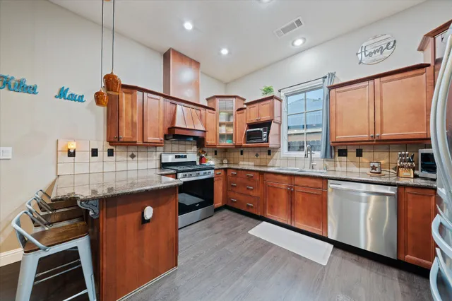 a kitchen with stainless steel appliances granite countertop a stove sink and cabinets