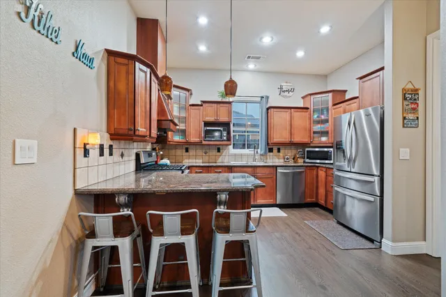 a kitchen with granite countertop a sink appliances and cabinets