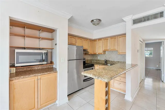 a kitchen with a refrigerator sink and cabinets