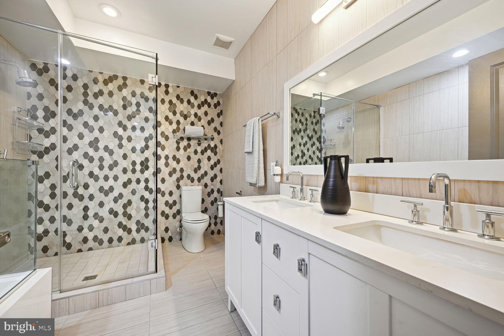 1143 5th Street Northeast, Unit 1 Washington, DC 20002 - Photo 20 of 54 a bathroom with a double vanity sink toilet and shower