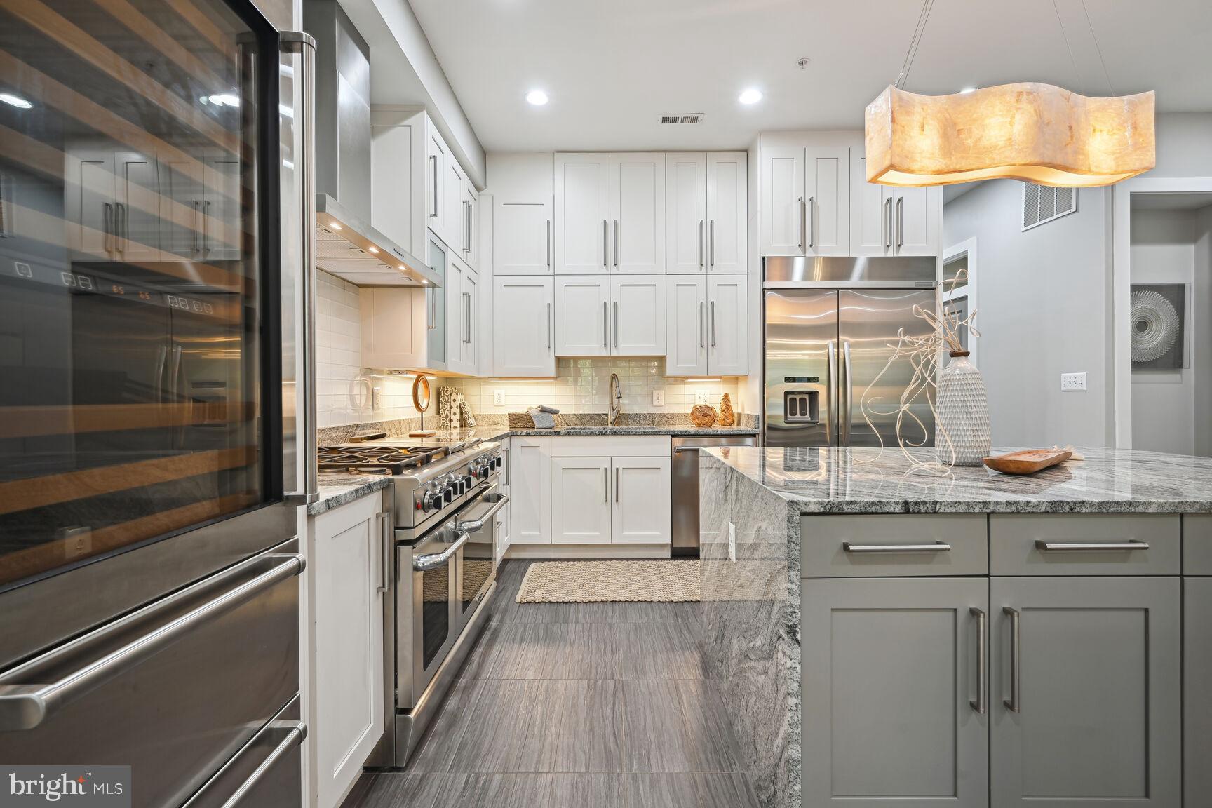 1143 5th Street Northeast, Unit 1 Washington, DC 20002 - Photo 5 of 54 a kitchen with kitchen island granite countertop lots of counter top space and stainless steel appliances
