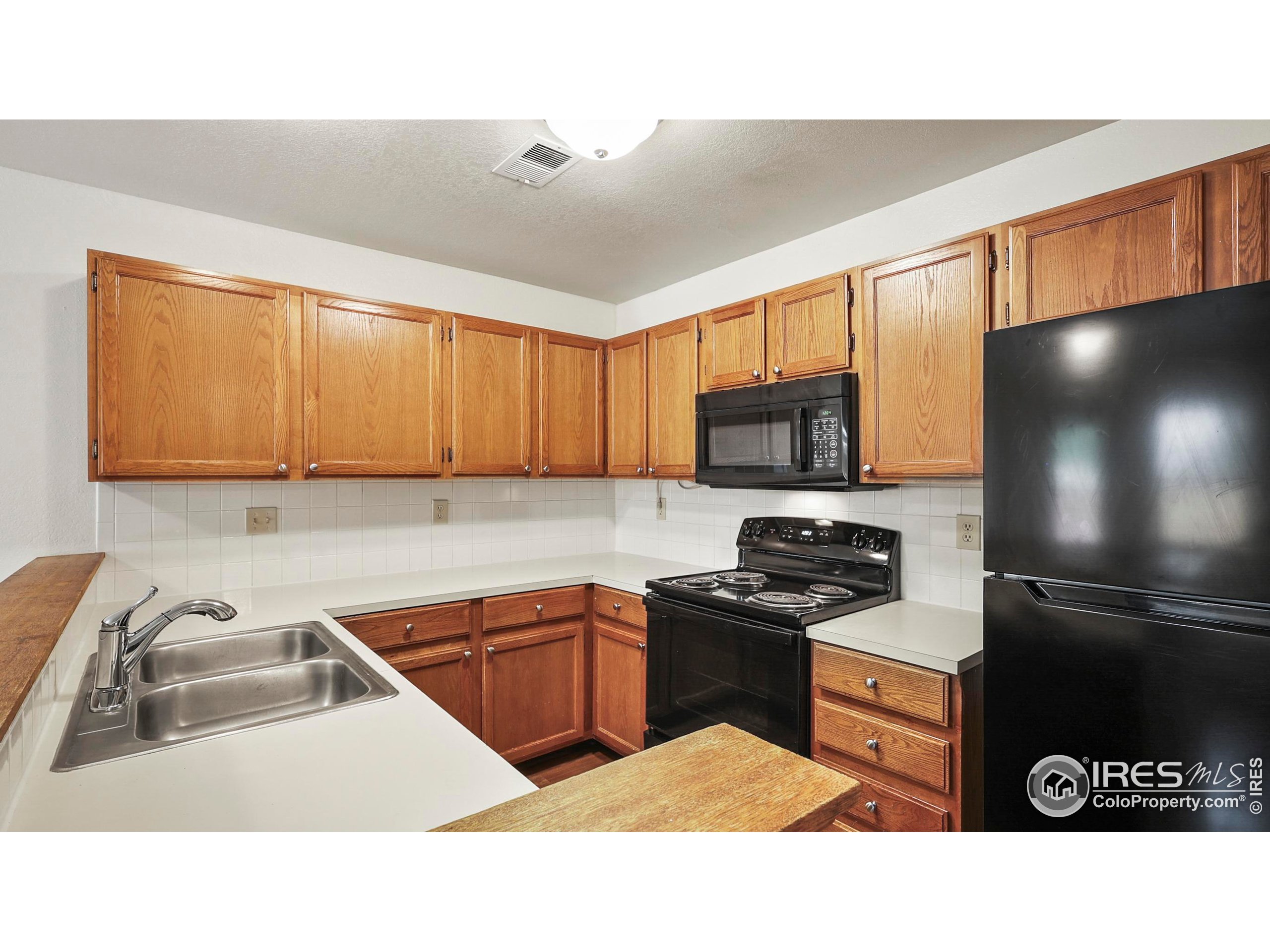5809 West 18th Street Greeley, CO 80634 - Photo 6 of 25 a kitchen with a sink a stove and cabinets