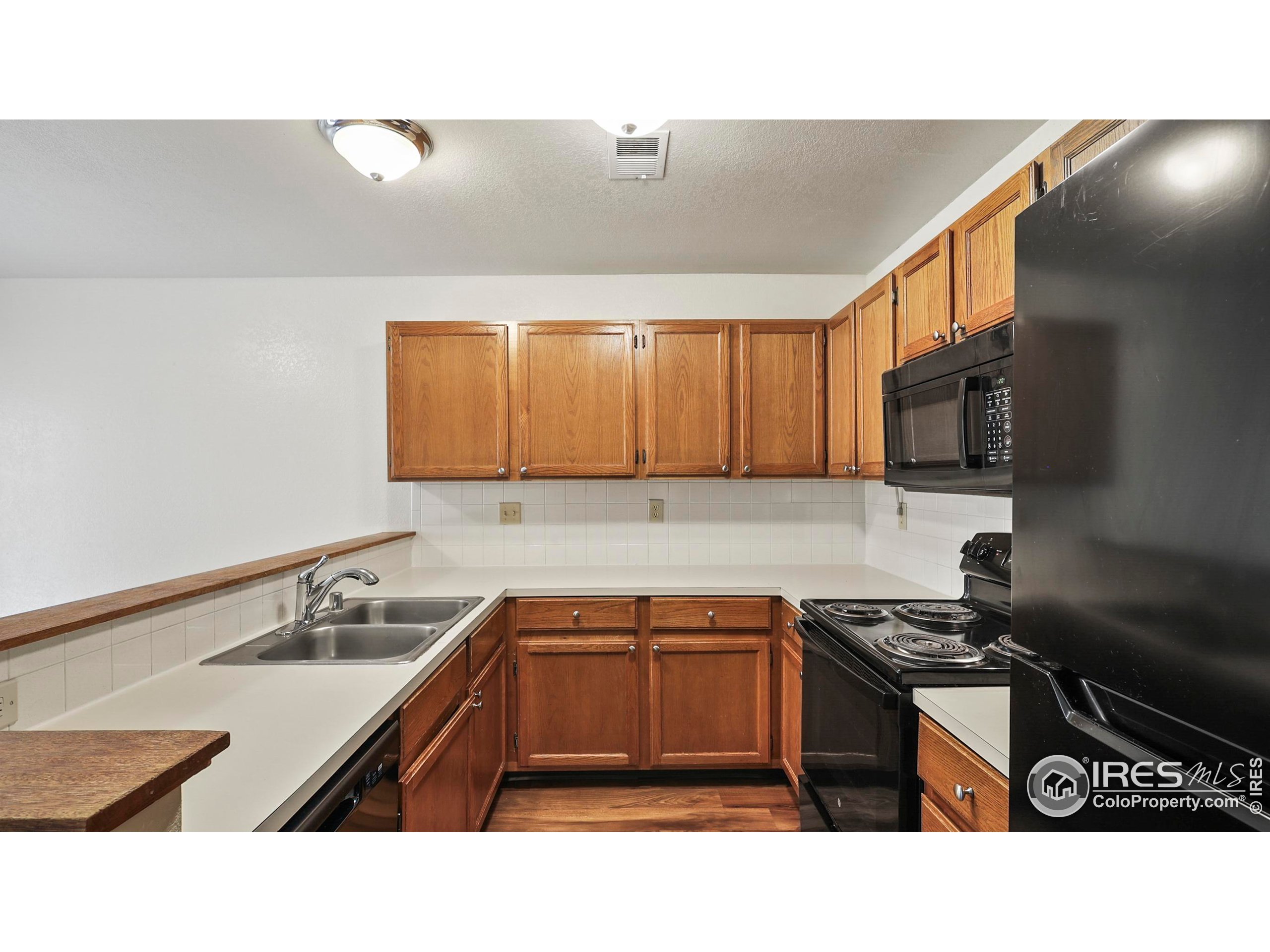 5809 West 18th Street Greeley, CO 80634 - Photo 7 of 25 a kitchen with stainless steel appliances granite countertop a sink stove and microwave