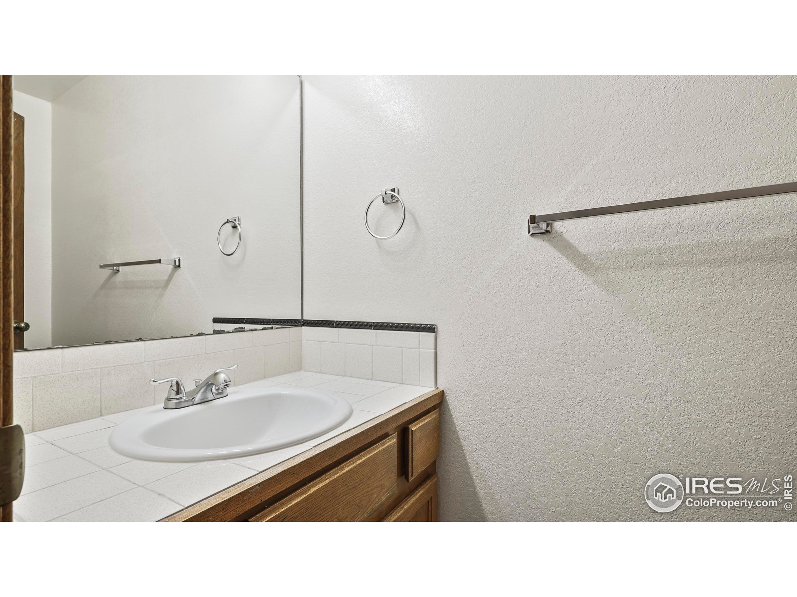 5809 West 18th Street Greeley, CO 80634 - Photo 10 of 25 a bathroom with a sink and a mirror