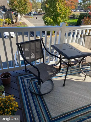 a view of a patio with table and chairs with wooden floor and fence