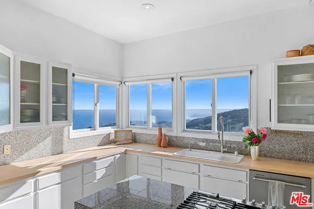 a kitchen with a table chairs a sink dishwasher stove and cabinets with wooden floor