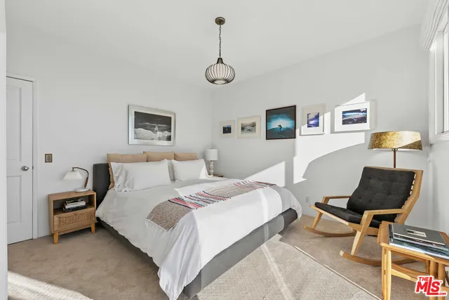 a bedroom with a large bed and a chandelier