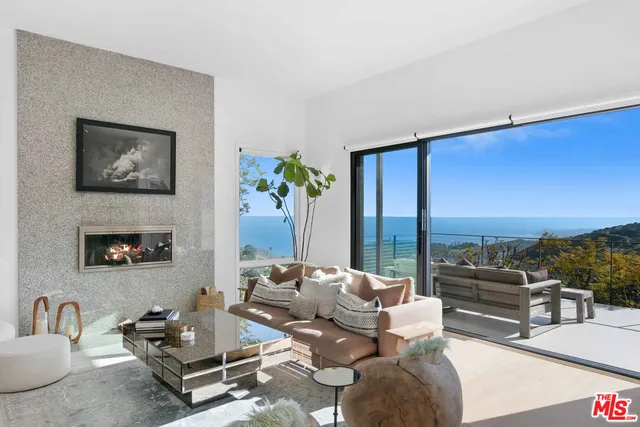a living room with furniture and a floor to ceiling window