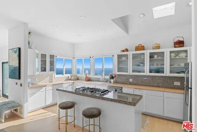 a kitchen with granite countertop sink and natural light