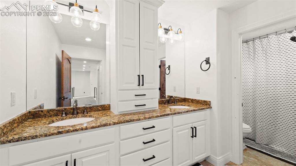 13625 Random Ridge View Colorado Springs, CO 80921 - Photo 34 of 50 Bathroom with double vanity and a shower with shower curtain