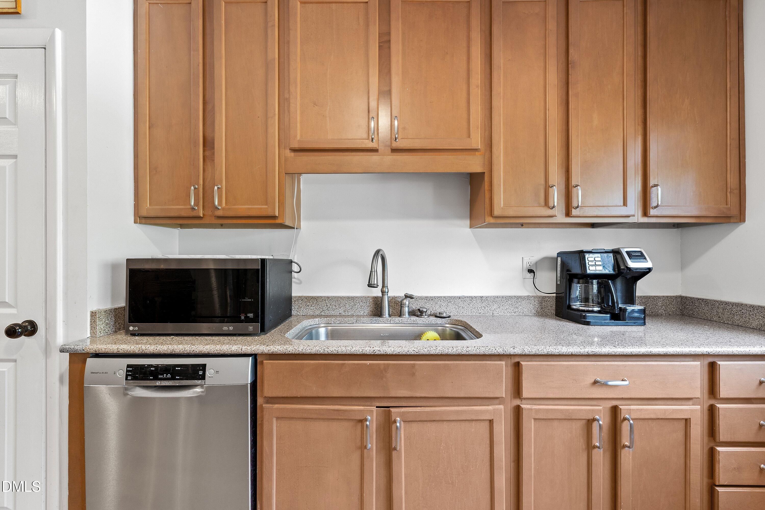 1445 Sedwick Road Durham, NC 27713 - Photo 11 of 48 a kitchen with stainless steel appliances granite countertop a sink a stove and a microwave