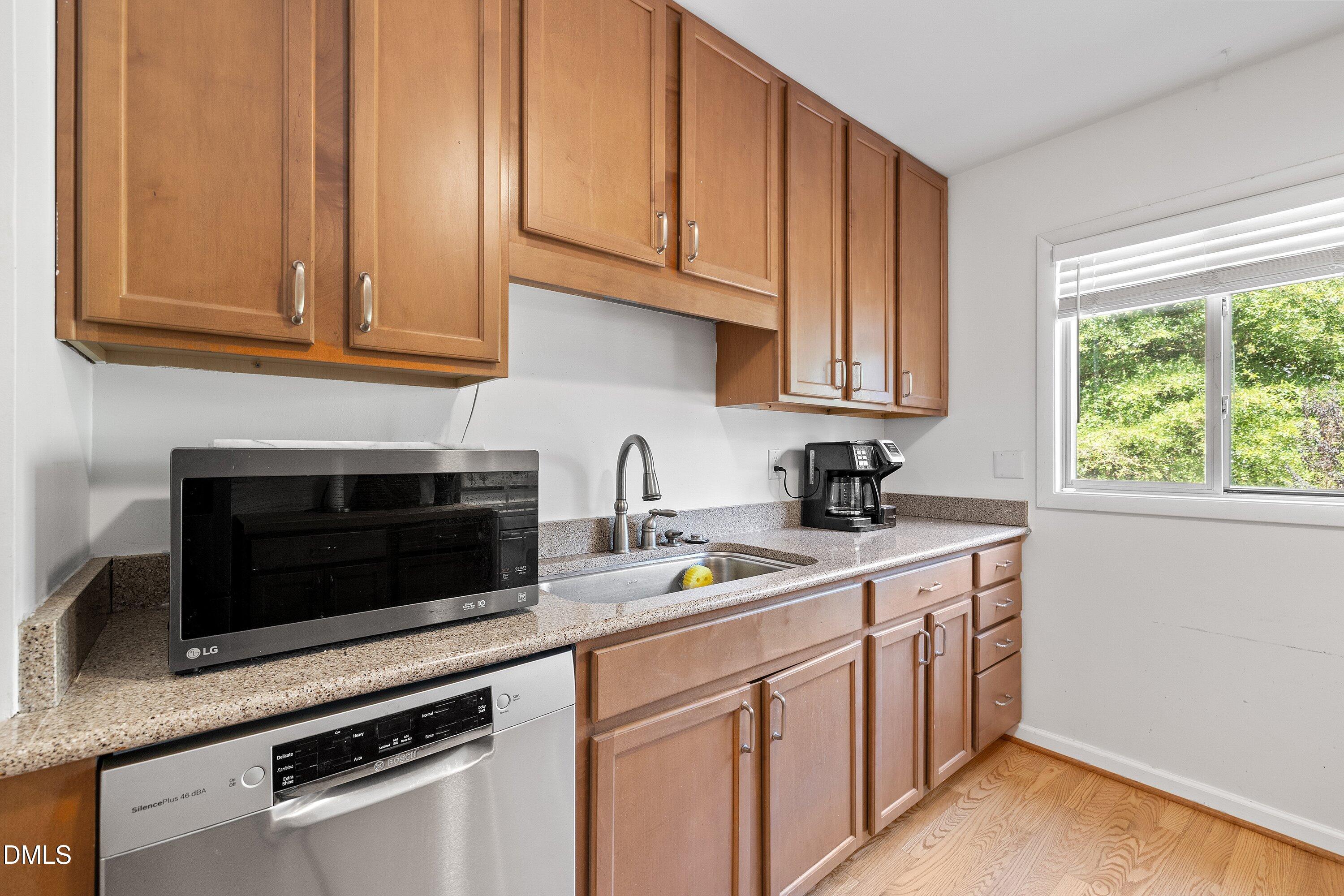 1445 Sedwick Road Durham, NC 27713 - Photo 12 of 48 a kitchen with stainless steel appliances granite countertop a sink stove and microwave