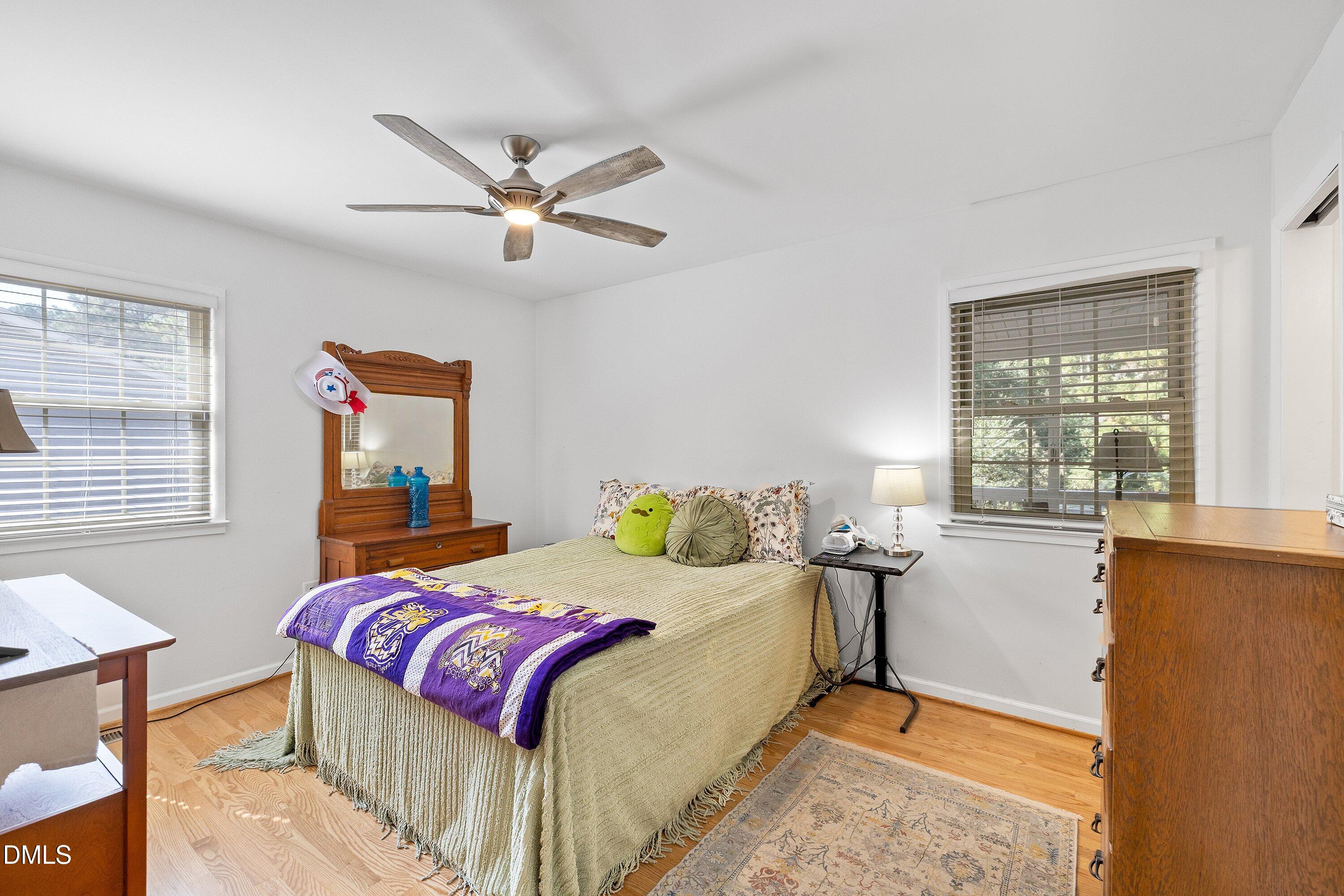 1445 Sedwick Road Durham, NC 27713 - Photo 18 of 48 a bedroom with a bed and wooden floor