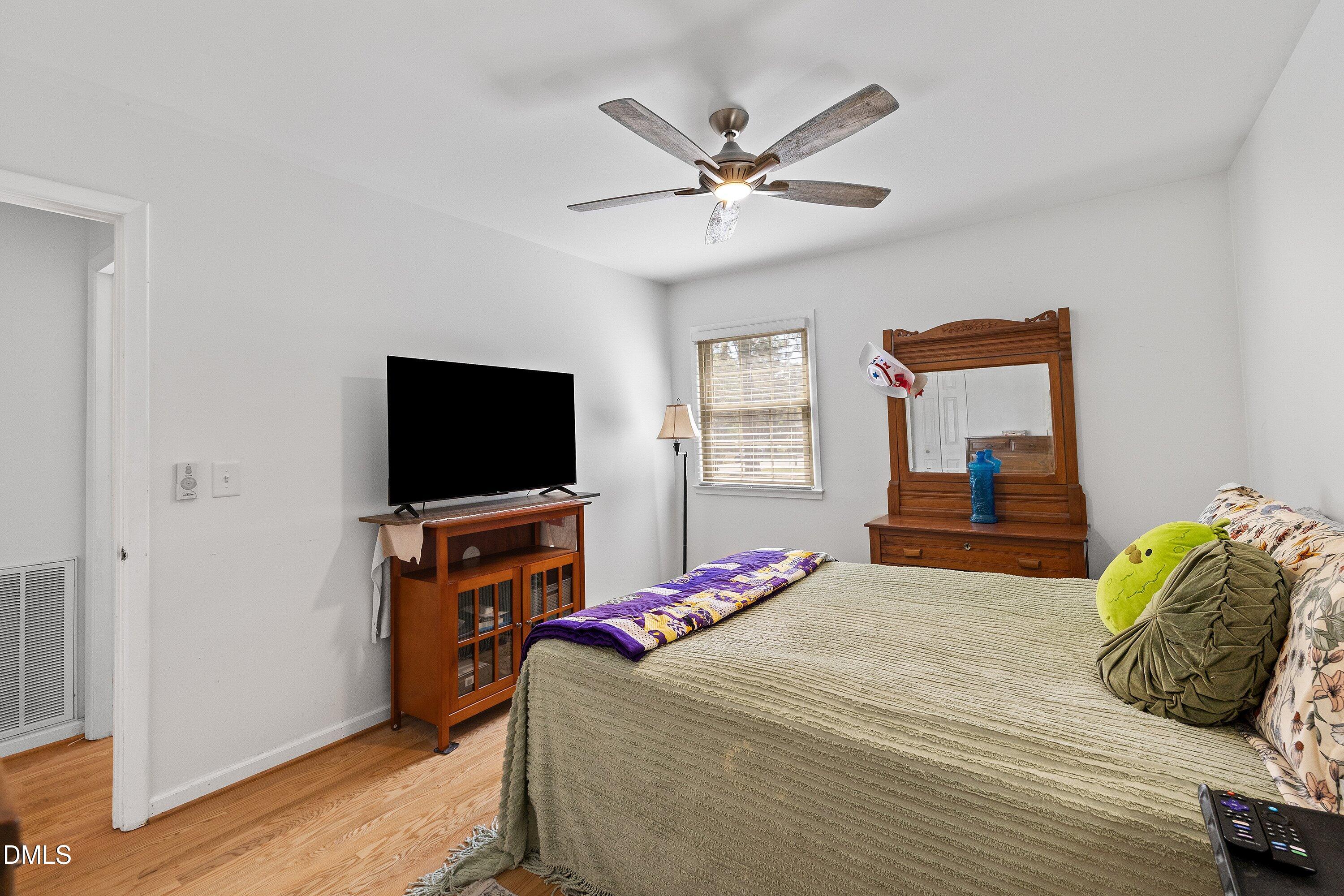 1445 Sedwick Road Durham, NC 27713 - Photo 21 of 48 a bedroom with a bed and a flat screen tv