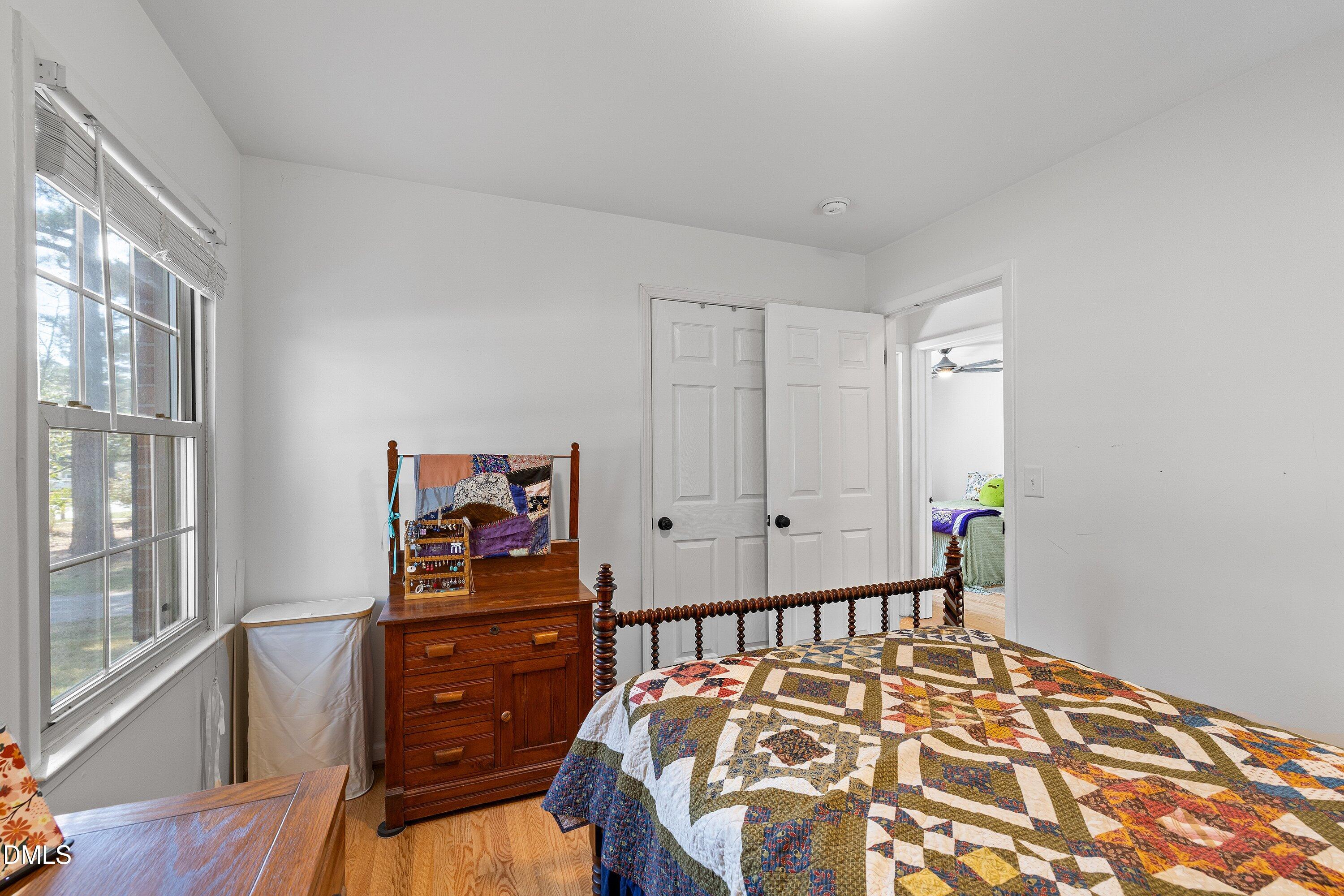 1445 Sedwick Road Durham, NC 27713 - Photo 24 of 48 a bedroom with a bed and wooden floor