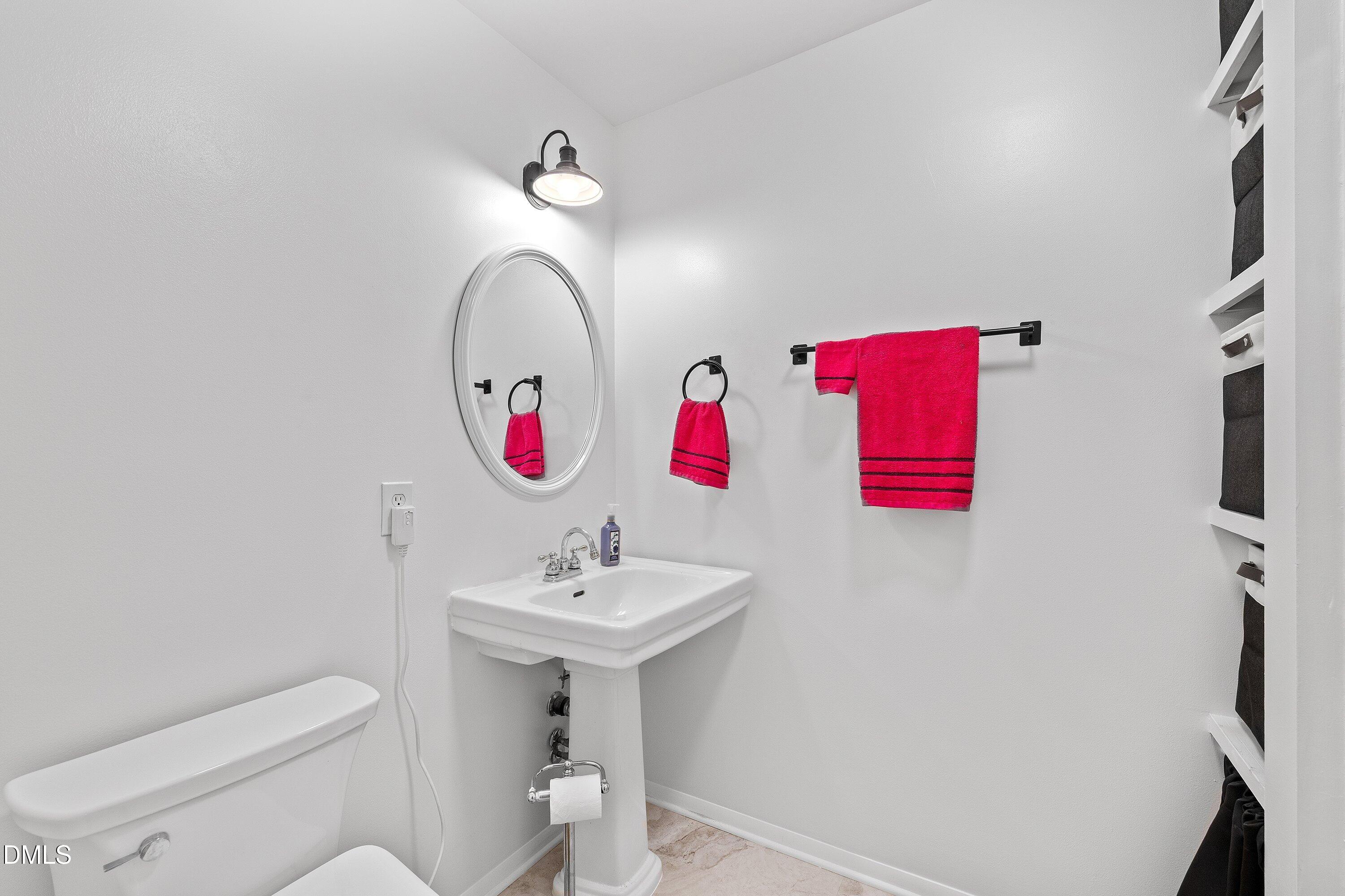 1445 Sedwick Road Durham, NC 27713 - Photo 27 of 48 a bathroom with a sink mirror and toilet